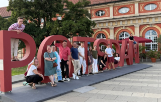 Teilnehmende in Potsdam stehend vor dem Potsdam-Schriftzug.