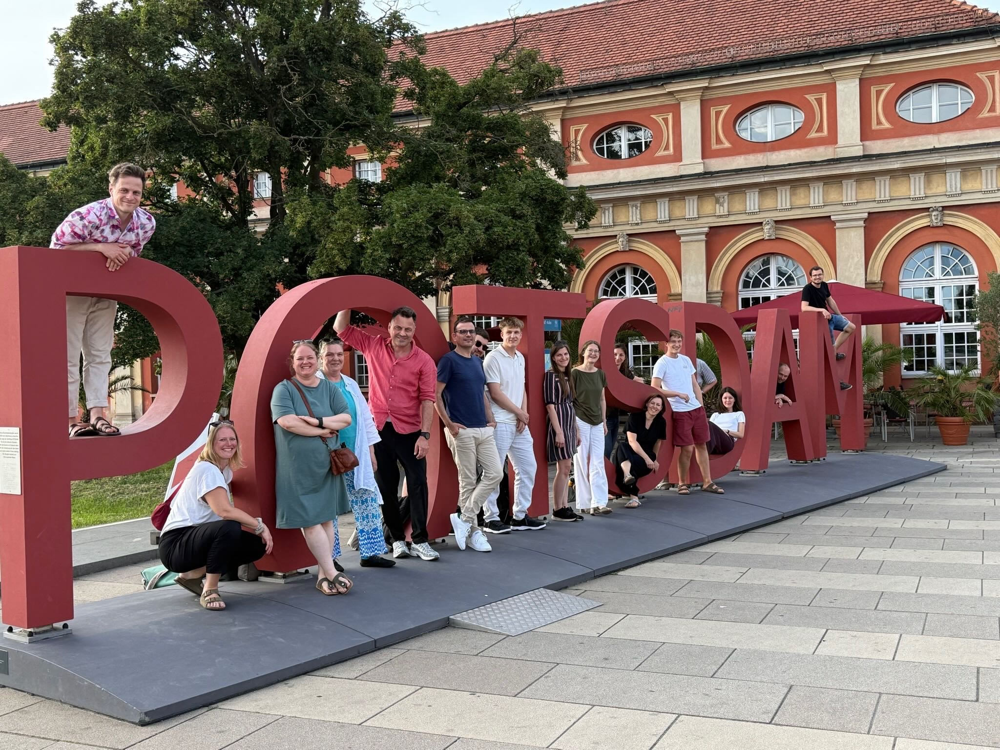 Teilnehmende in Potsdam stehend vor dem Potsdam-Schriftzug.