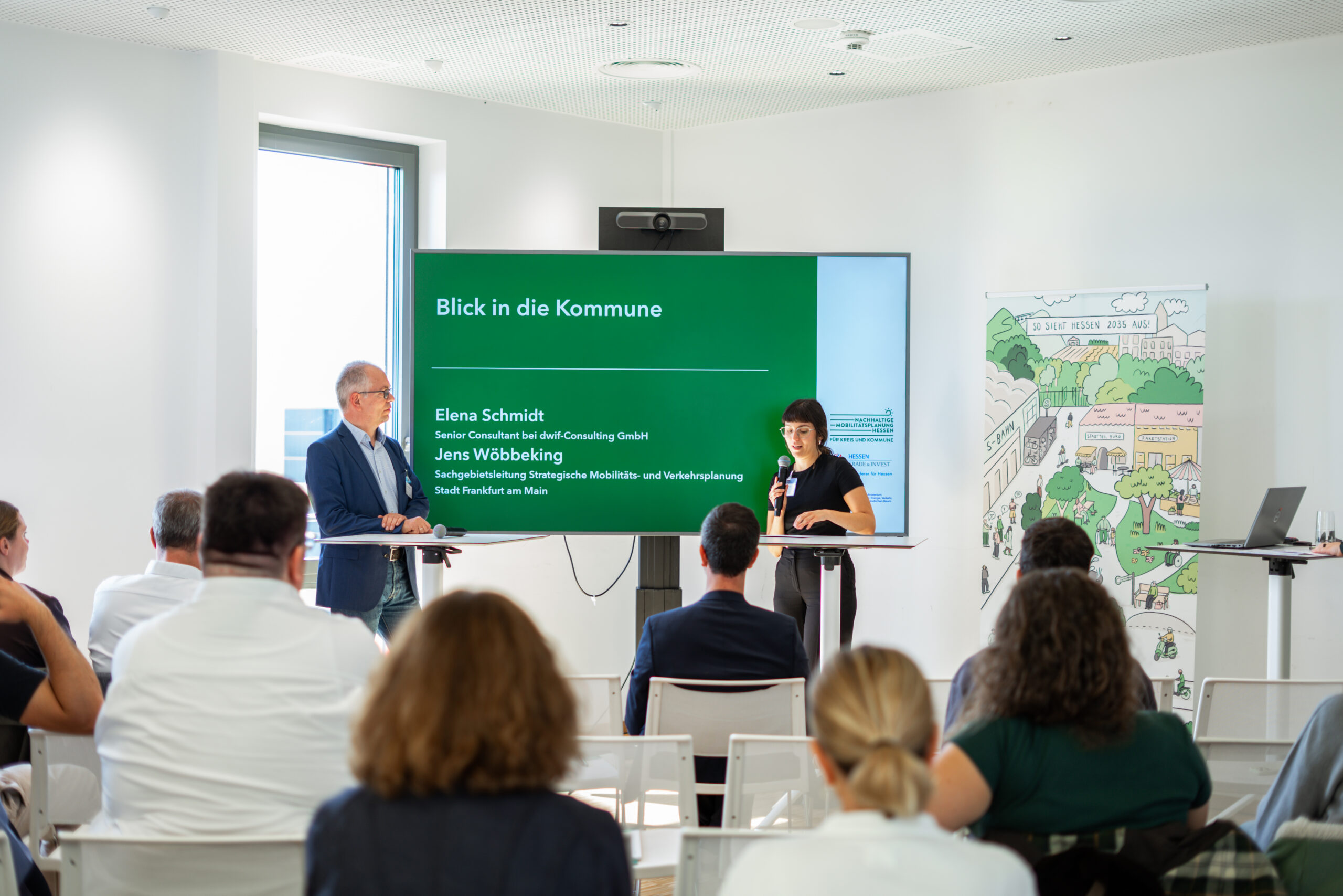 Jens Wöbbeking (Stadt Frankfurt) im Talk mit Elena Schmidt (dwif-Consulting) zum Thema „Mobilität im Tourismus“. Jens Wöbbeking von der Stadt Frankfurt und Elena Schmidt vom dwif-Consulting stehen auf der Präsentationsfläche und unterhalten sich zum Thema "Mobilität im Tourismus".