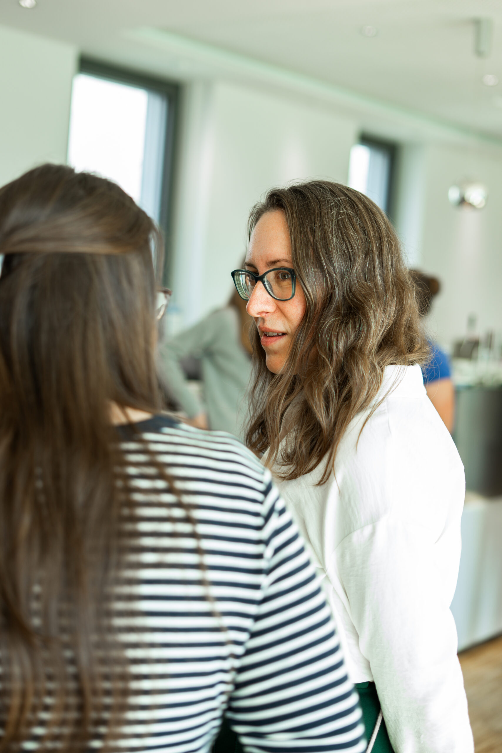 Dr. Alesya Krit – Themenfeldleiterin des Fachzentrums – tauscht sich mit einer Teilnehmerin aus. Teilnehmerinnen beim Netzwerken.